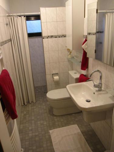 biała łazienka z toaletą i umywalką w obiekcie Ferienwohnung Kleinschmidt w mieście Heimbach