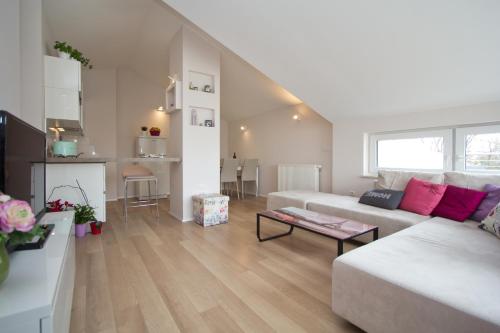 uma sala de estar com um sofá branco e uma mesa em Apartments Adria em Porec