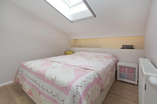 a small bedroom with a bed with a pink bedspread at Apartments Adria in Poreč