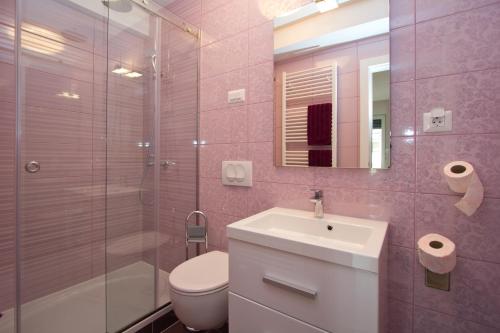 a bathroom with a sink and a toilet and a shower at Apartments Adria in Poreč