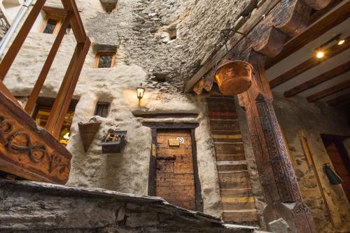 an old stone building with a wooden door and stairs at Au Coeur Des Alpes in Villarodin-Bourget