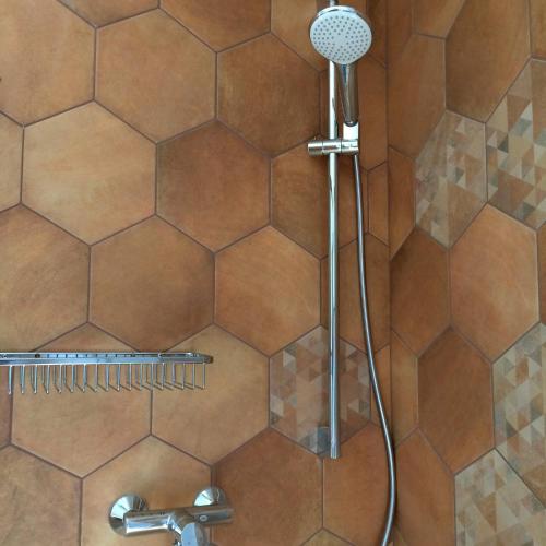 a shower with a shower head in a bathroom at Ursa Minor in Sumartin