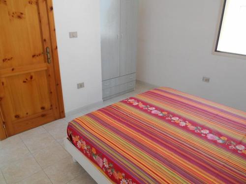 ガリポリにあるBilocale al mare Baia Verdeのベッドルーム1室(カラフルな毛布付きのベッド1台付)