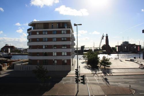 a tall apartment building next to a street at Ferienwohnungen an der Weser in Bremerhaven