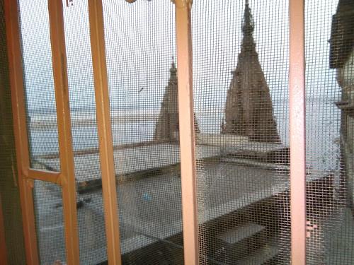 a view through a barred window of a building at Bhadra Kali Guest House in Varanasi