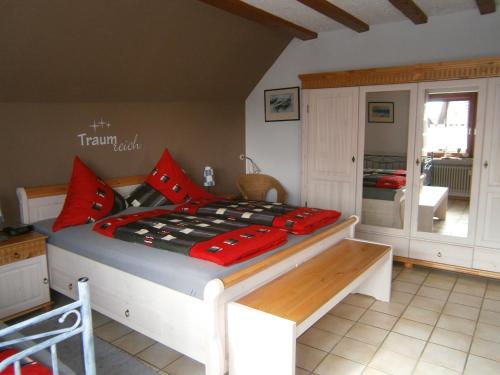 een slaapkamer met een bed met rode kussens bij Ferienwohnung Abendsonne am Europa-Park in Rheinhausen