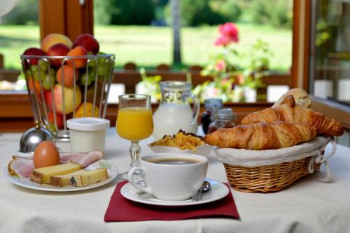 a table with breakfast foods and a cup of coffee at L'auberge Des 3 Ponts in Cusance