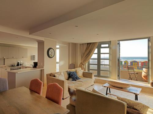 ein Wohnzimmer mit Sofa und Tisch in der Unterkunft Surferscorner Self Catering Apartments in Muizenberg