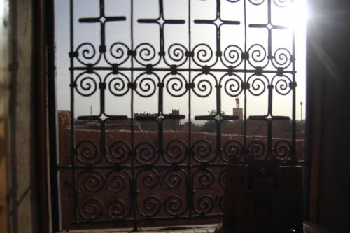 an iron gate with a view of a building at Maison d'hôtes Dar El Nath in Ouarzazate