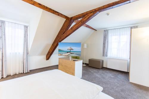 Schlafzimmer mit einem weißen Bett und Fenstern in der Unterkunft Hotel Jägerhaus in Esslingen in Esslingen