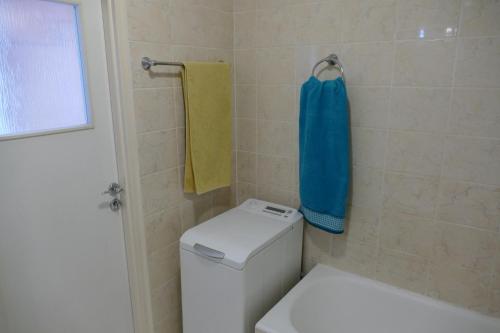a bathroom with a toilet and a blue towel at Apartamenty Olimp in Gdańsk