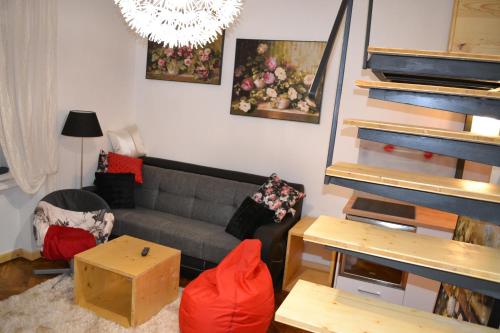 Una sala de estar con un sofá y una escalera. en Bastion Apartament 5, en Timisoara