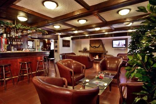 een bar met lederen stoelen en een tafel in een kamer bij TES Flora Apartments in Borovets
