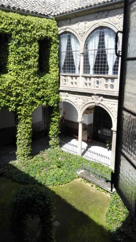 an ivy covered house with a white fence and windows at Palacio de la Rambla in Úbeda