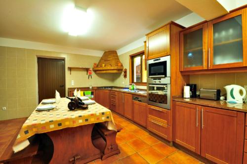 a kitchen with a table in the middle of it at Casa da Rocha in Calheta