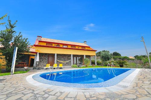 a swimming pool in front of a house at Casa da Rocha in Calheta