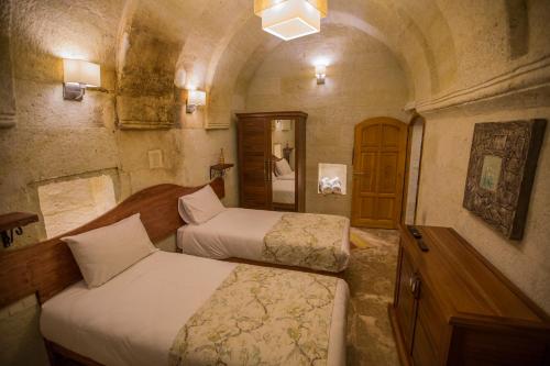 a bedroom with two beds in a room at Agarta Cave Hotel in Goreme