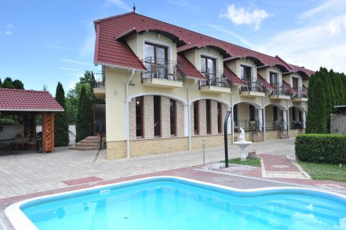 a house with a swimming pool in front of it at Bajor Panzió Bük-Bükfürdő, Adults Friendly 12 Plus in Bük