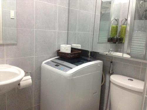a bathroom with a washing machine and a sink at Sea Residences MoA Manila in Manila