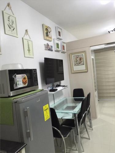 a dining room with a table and a microwave at Sea Residences MoA Manila in Manila