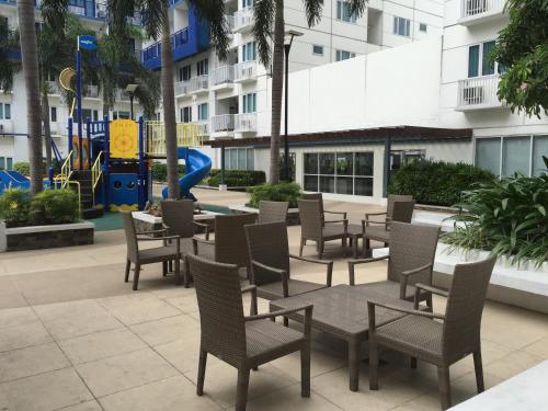 a patio with chairs and tables and a playground at Sea Residences MoA Manila in Manila