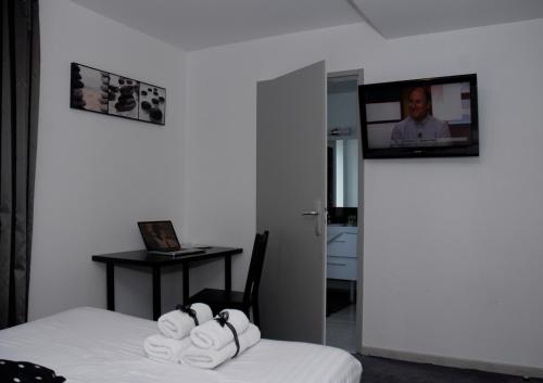 a room with a bed and a tv on the wall at La Source in Porcieu-Amblagnieu