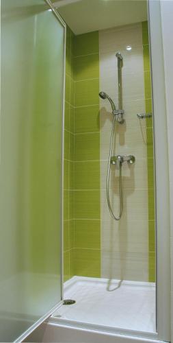 a bathroom with a shower with green tiles at La Source in Porcieu-Amblagnieu