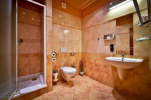 a bathroom with a toilet and a sink and a shower at Atlantic Hotel in Prague