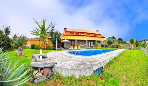 a house with a swimming pool in the yard at Casa da Rocha in Calheta