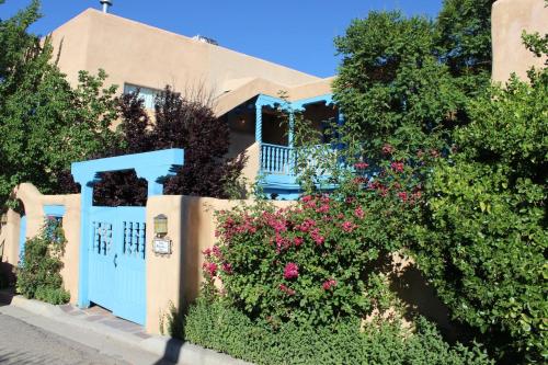 a house with a blue gate and flowers at Casa Benavides Inn in Taos