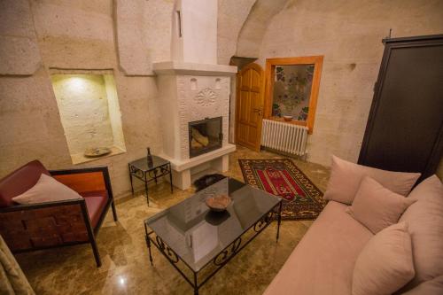 a living room with a couch and a fireplace at Agarta Cave Hotel in Goreme