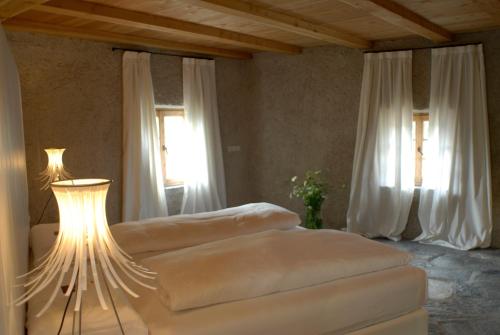 a bedroom with two beds and a table with a lamp at Grottnerhof in Völs am Schlern