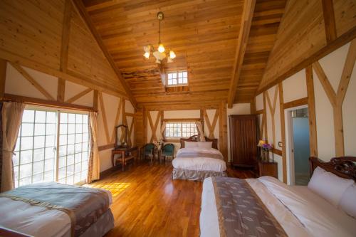 a bedroom with two beds in a room with wooden ceilings at The Cotswolds Villa in Renai