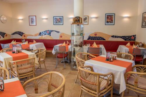 a restaurant with tables and chairs in a room at Hotel Kalma, Kalma Villa, Apart Hotel in Hévíz