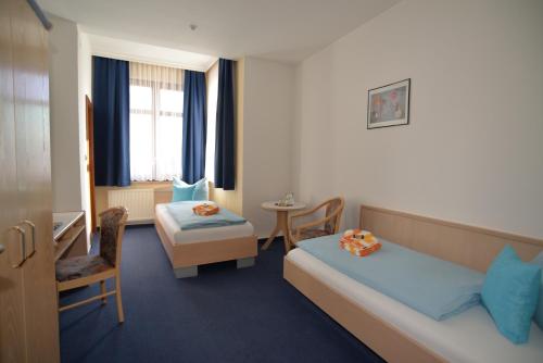 ザールフェルトにあるHotel Am Hohen Schwarmのベッドとテーブルが備わるホテルルームです。