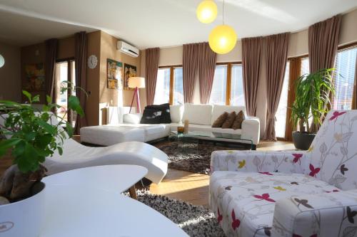 a living room with white furniture and windows at Farah Superior Apartments in Bihać