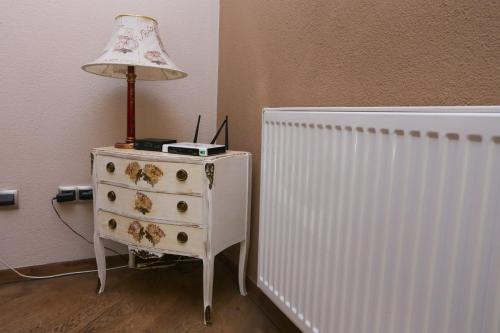 a lamp on a dresser next to a radiator at Farah Superior Apartments in Bihać