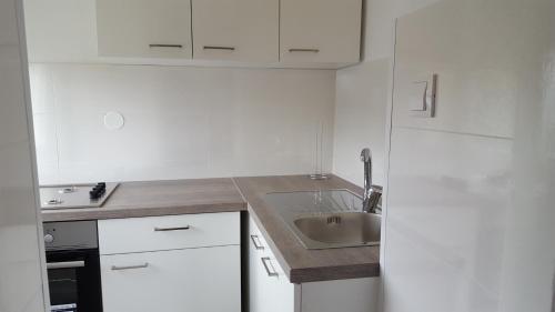 - une cuisine blanche avec un évier et un comptoir dans l'établissement Apartment Sibenik with free parking, à Šibenik