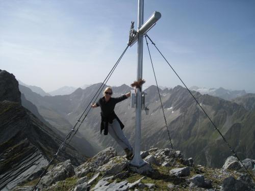 a man is posing in front of a cross on a mountain at Boutique Appartments Gerlosperle in Gerlos