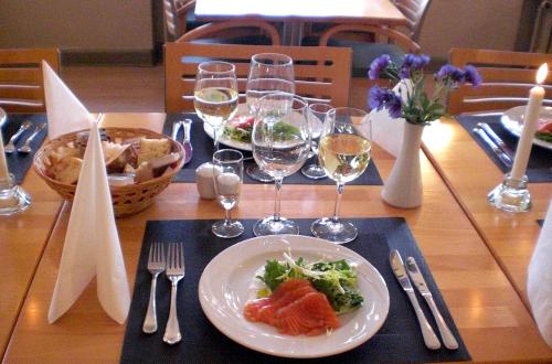 a table with a plate of food and wine glasses at Hotel Kong Valdemar in Vordingborg