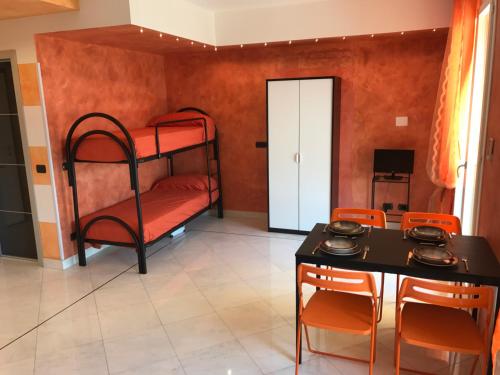 サンレモにあるFlat acquamarinaの二段ベッド、テーブル、椅子が備わる客室です。