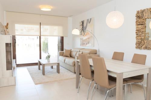 a dining room and living room with a table and chairs at Mar de Pulpí Las Azucenas by Mar Holidays in San Juan de los Terreros