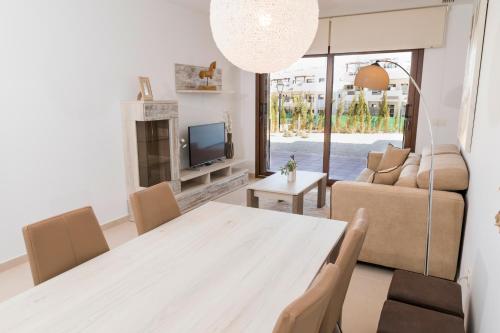 a living room with a table and a couch at Mar de Pulpí Las Azucenas by Mar Holidays in San Juan de los Terreros