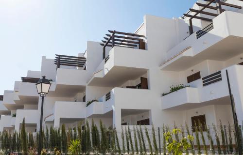 a white building with balconies and a street light at Mar de Pulpí Las Azucenas by Mar Holidays in San Juan de los Terreros