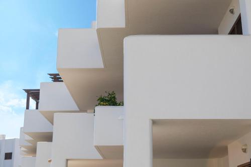 a facade of a building with white balconies at Mar de Pulpí Las Azucenas by Mar Holidays in San Juan de los Terreros