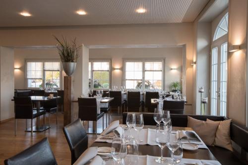 a dining room with tables and chairs and windows at Gasthaus zum Bahnhof in Berg