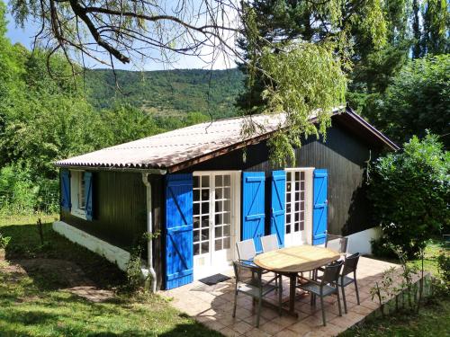 a small house with blue doors and a table at Chalet with garden in the Pyrenees in Roquefort-de-Sault