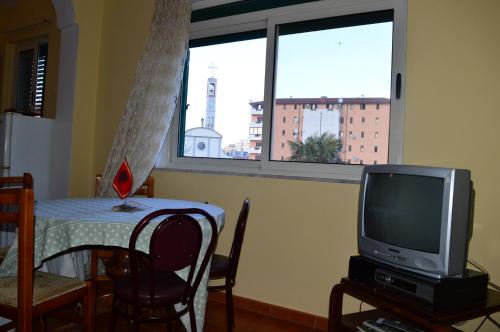 a living room with a table and a television at Arka Hostel in Shkodër