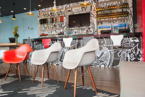 a group of chairs in a restaurant with a wall of graffiti at ibis Rio Porto Atlantico in Rio de Janeiro