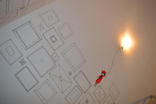 a drawing of a person on a wall with a light at Arka Hostel in Shkodër